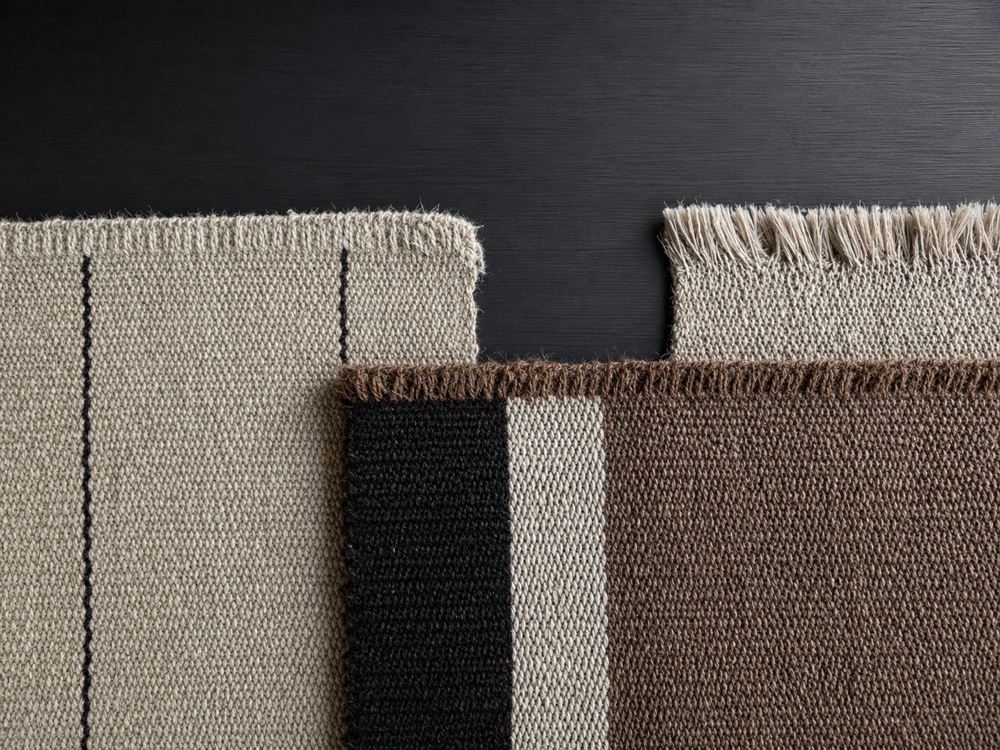 Three handwoven goat hair fabric samples in cream, black and brown tones